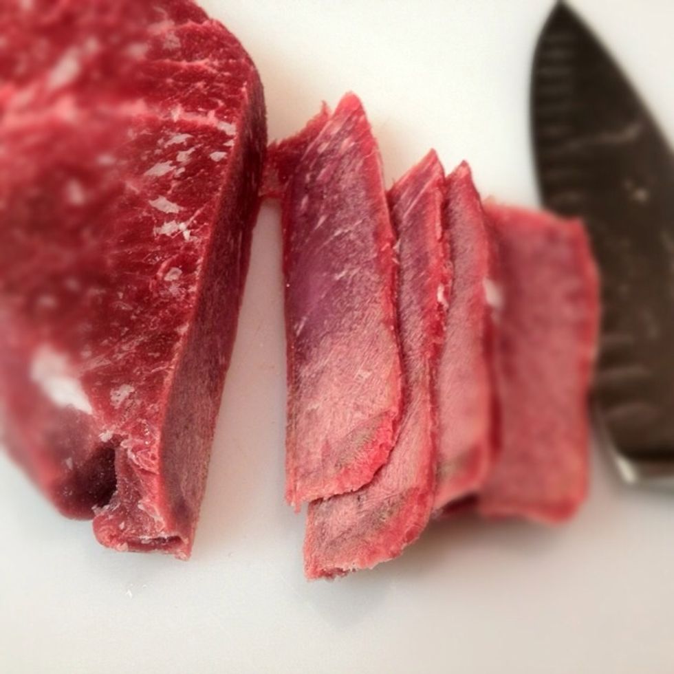 Uniform slices diagonal across the grain. Think: thick bacon. Trim off all edge fat! It's gross if you leave it on.