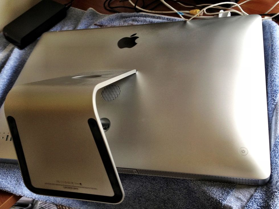 Unplug all cables from the machine & carefully lay it face down on a large soft towel or blanket