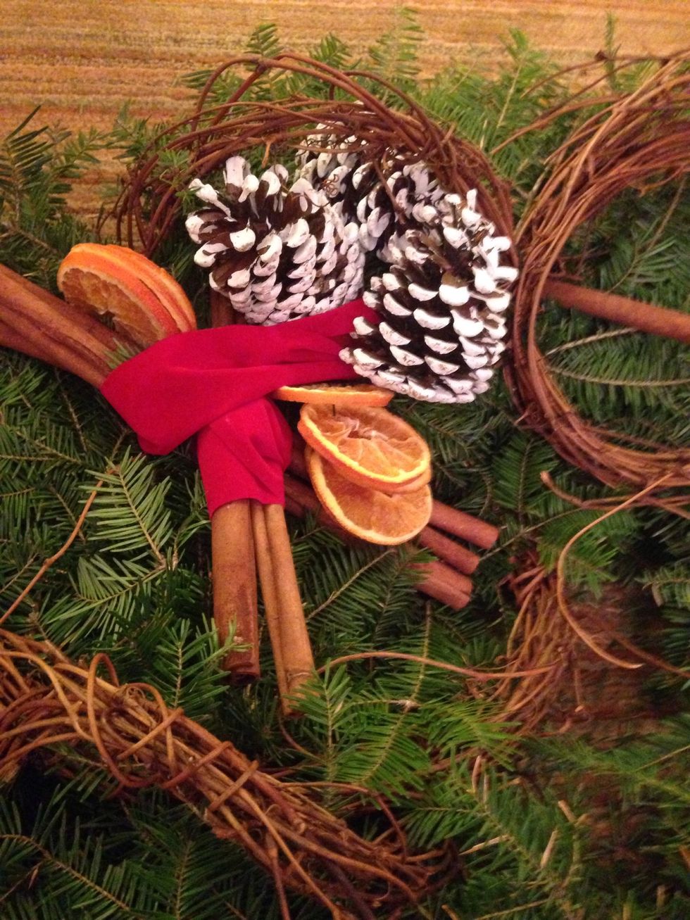 Unravel the velvet bow and use pieces of it to wrap around the grapevine garland and cinnamon sticks.
