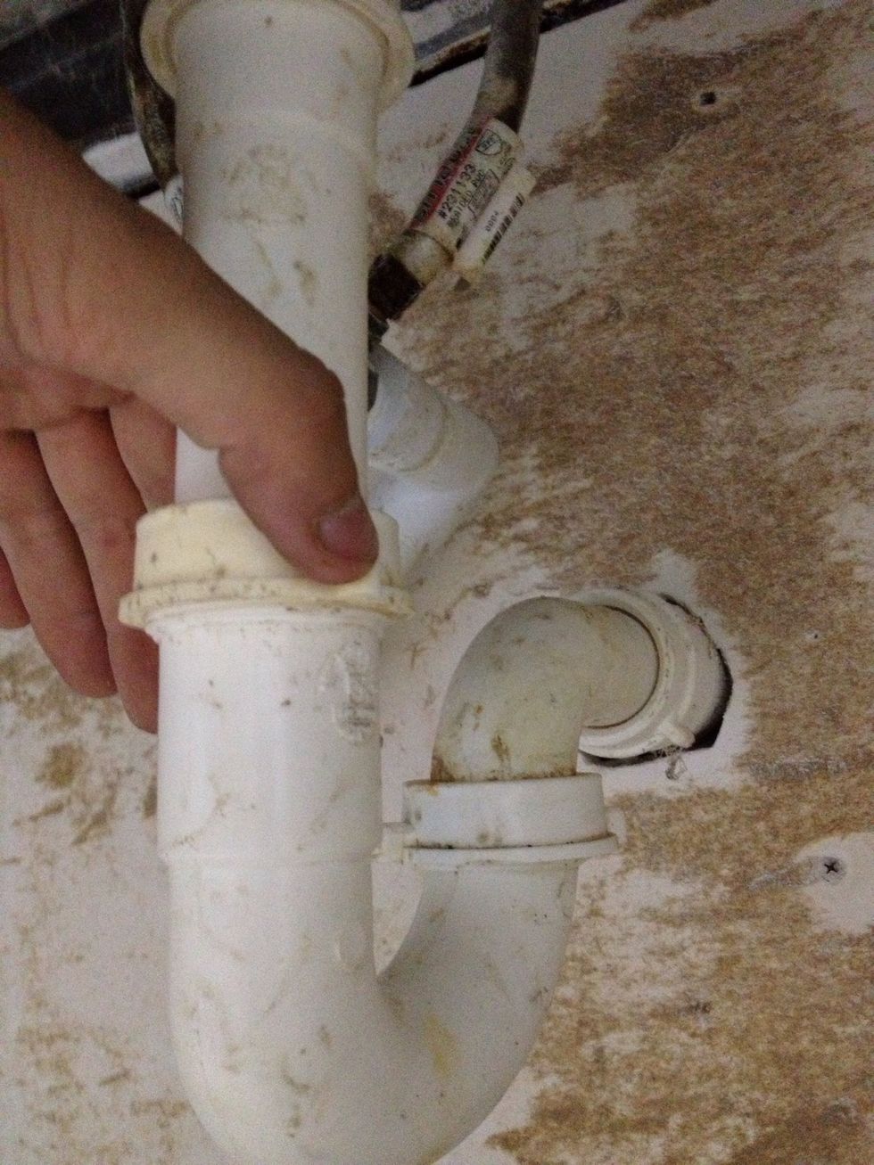 Unscrew the plastic fasteners connecting each end of the trap to the other pipes. They should loosen by hand. If they don't, maybe you're turning them the wrong way, or maybe you'll need a wrench.