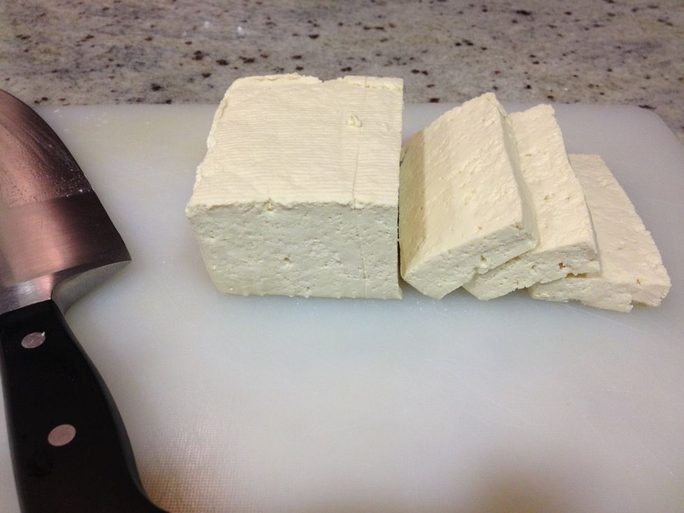 Unwrap the tofu, and slice like a loaf of bread. Slices should be about 1/2 inch thick.