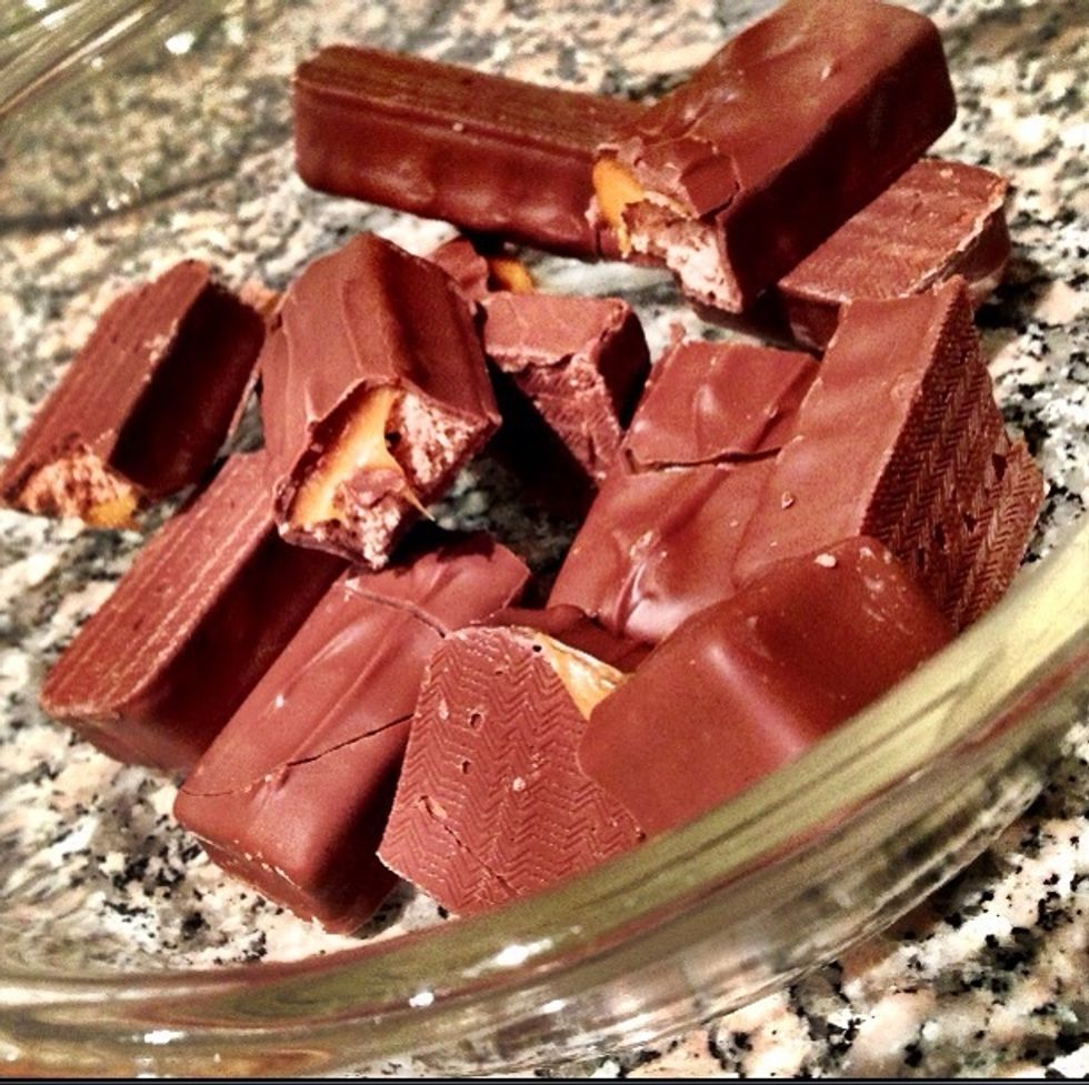 Unwrap your Mars Bars and put them in your Pyrex or Microwave-friendly container. Cut them in half, so that it'll make the melting process easier and faster.