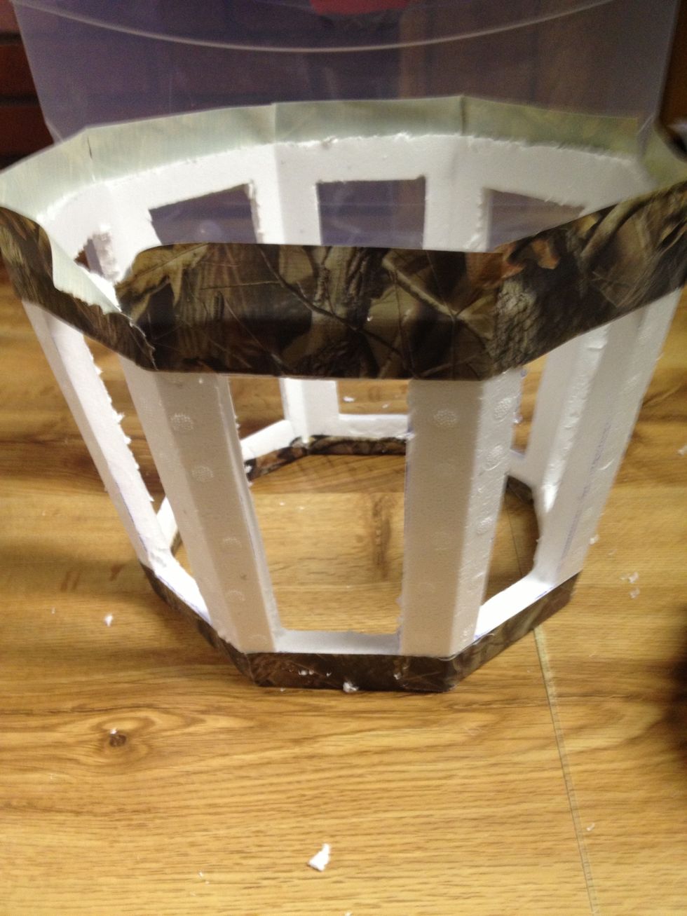 (Upside down) the tape on the bottom edge will be used to affix the foam to the lid of the tub. But not yet. Next step is hanging the work light. So grab the camouflage lid you made and make a hole