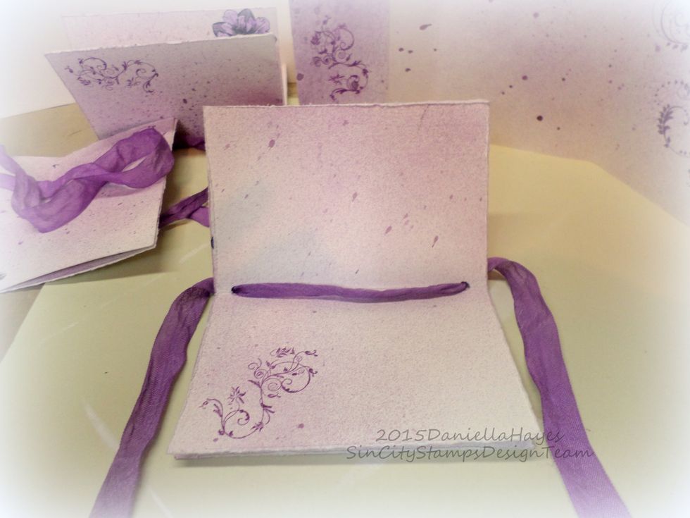 Use 1 yard of seam binding for each signature. Go in the bottom hole in the center of the signature and out through the top. Make sure the tails of the seam binding are even.