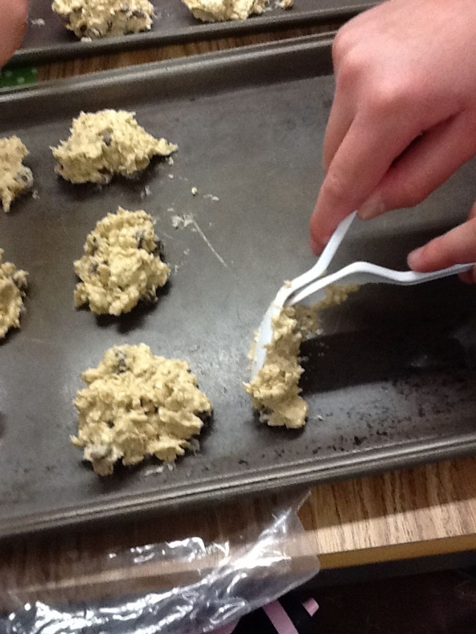 Use 2 spoons. 1 to scoop 1 to scrape onto the pan.