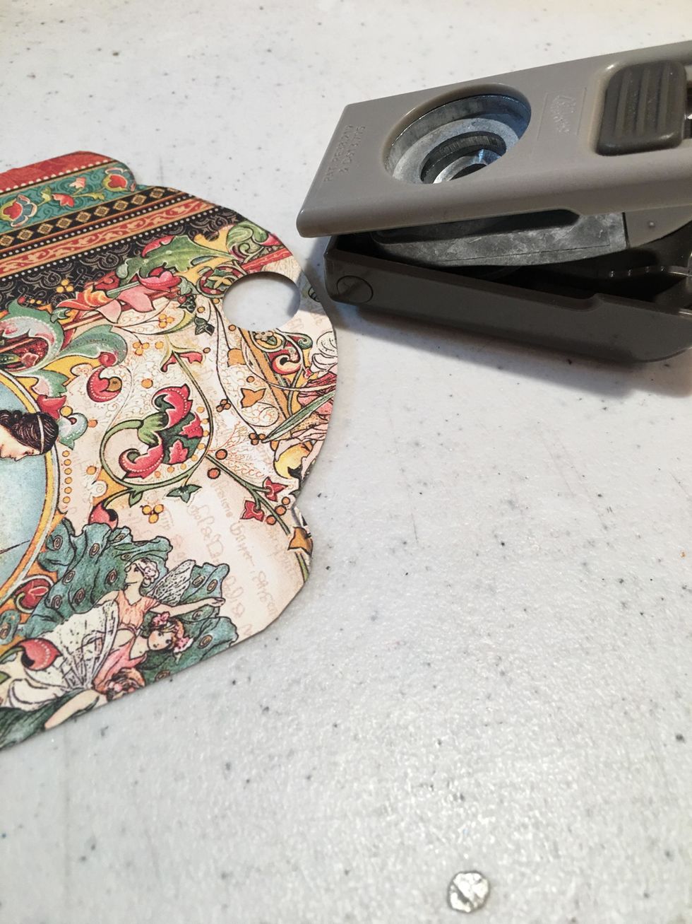 Use a 1/2" circle punch to punch out the hole for the grommet of the tags.  Do this in the patterned paper for the front and back of each tag.