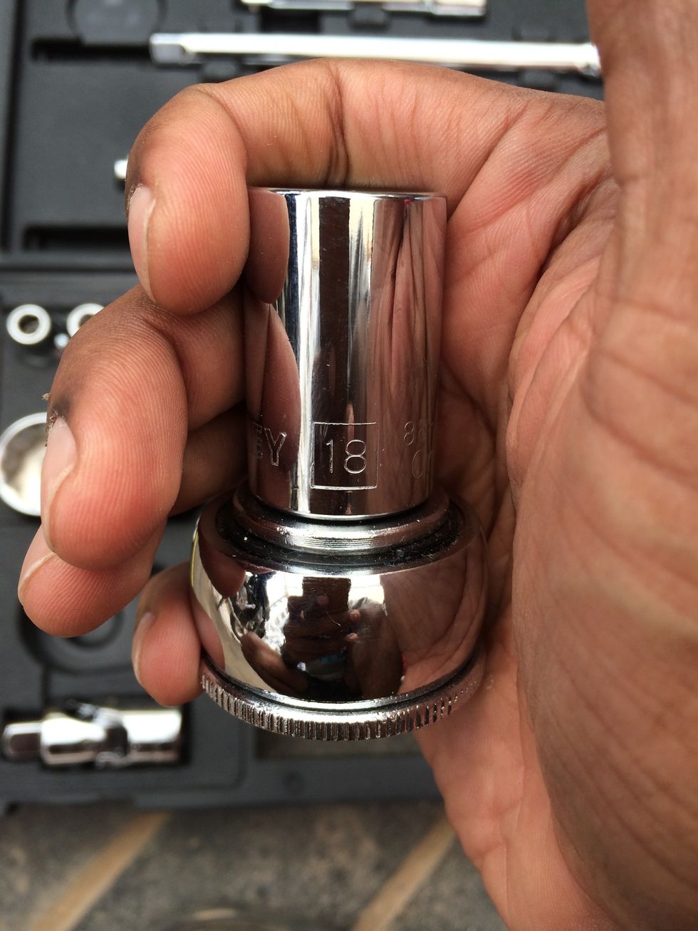 Use a 18mm socket wrench or ring spanner ( for better grip and access )