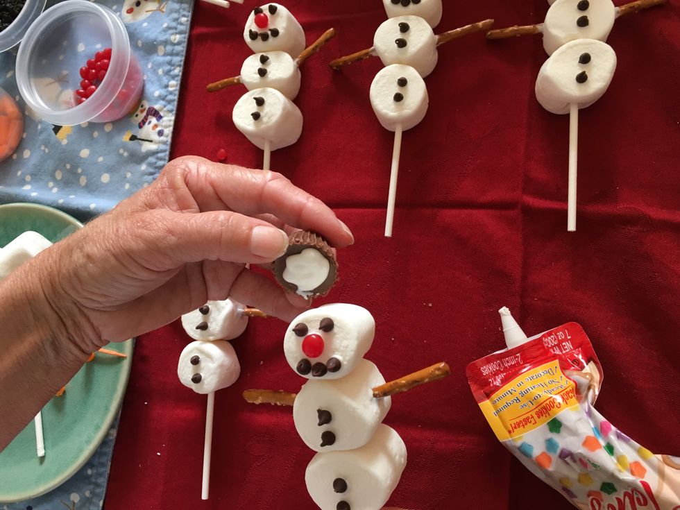 Use a big blob of cookie icing  placed on your reeses mini cups  to stick on the snowman's hat.  This is an optional step.