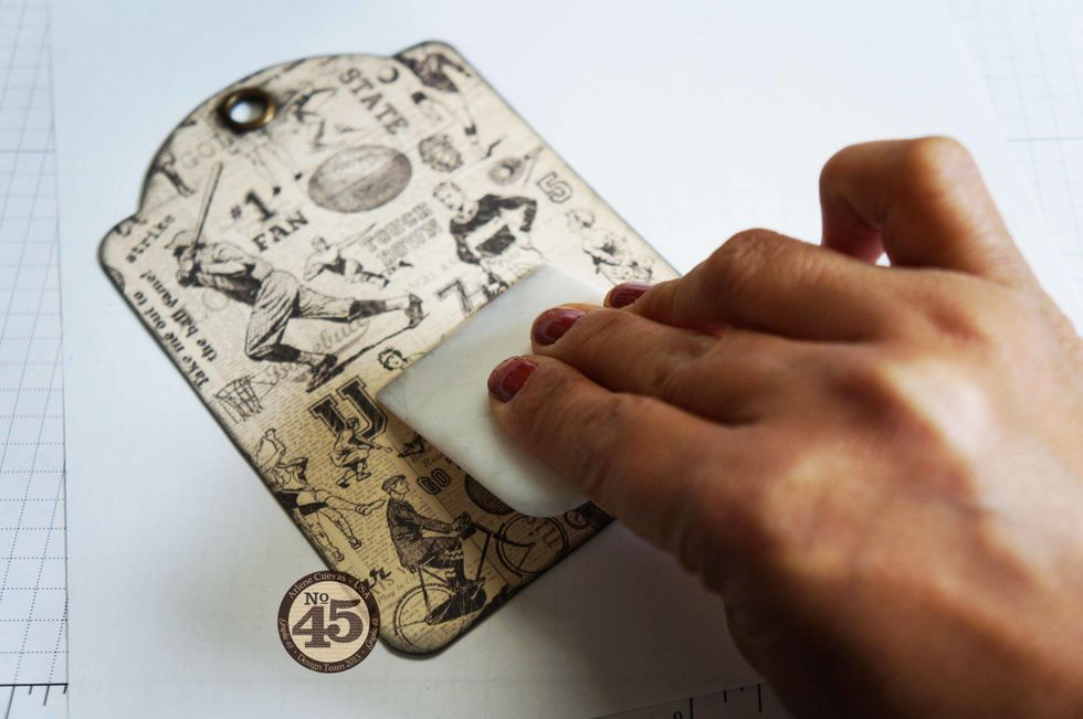 Use a bone folder to ensure design paper adheres well to the tag. This also pushes out any air pockets to ensure a firm hold.