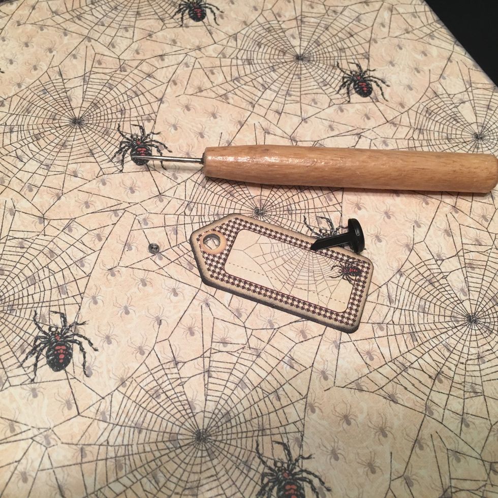 Use a brad piercing tool to punch a hole through the pattern paper only.  Attach the chipboard piece with a large brad.