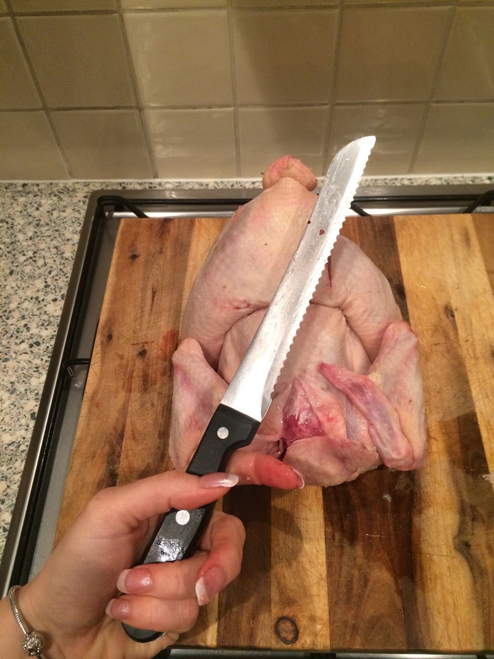 Use a bread knife or sharp strong knife to cut out "spine" bone. You can skip this part and cook the chicken whole but it will take longer to cook!