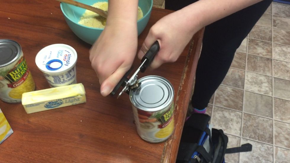 Use a can opener to open both of your cans of creamed corn. Then add them to your bowl.