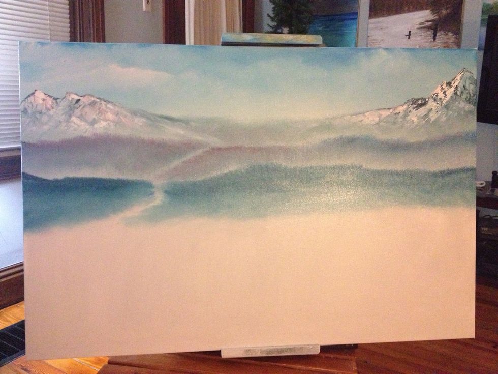 Use a chip brush to blend the mountain, then add whites and reds to your knife to add the snow. With the largest chip brush, blend the base of the mountain down and add some rolling hills.