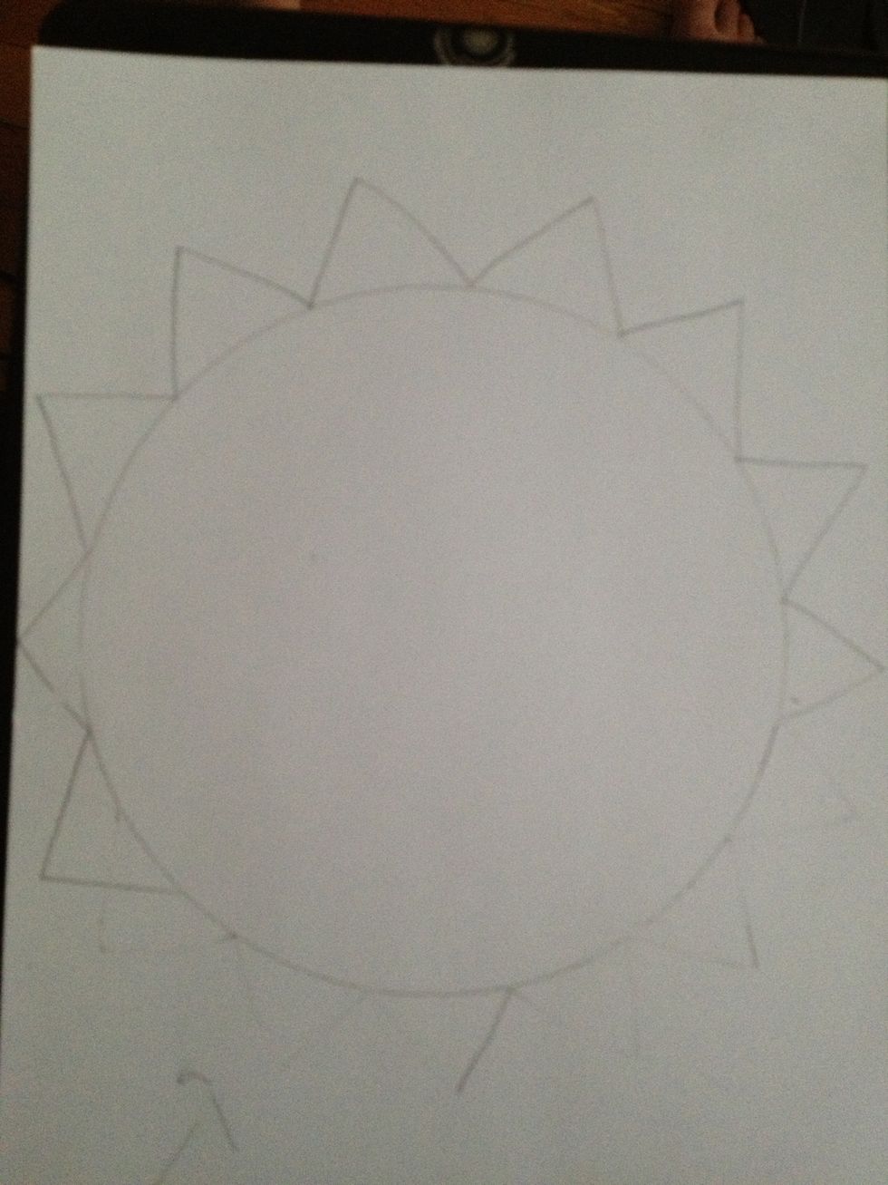 Use a circle tracer to trace your circle on to your paper. Then add an odd number of wide triangles to you circle to make the petals of your sunflower.