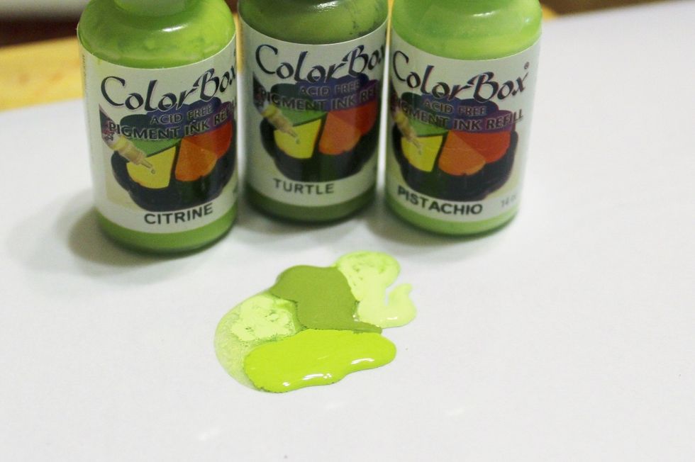 use a clean sheet from the Inking Palette to add "blobs" of Citrine, Turtle and Pistachio Pigment Inks and blend using a cleaned Color Wheel. use excess ink and Color Wheel to make green background...