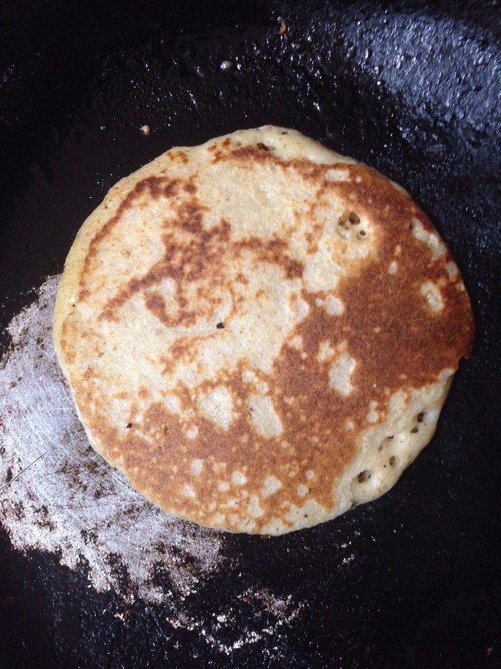 use a deeper spoon, put in the middle and grab the pan in the air and spread, back to the fire for few seconds and flip the pancake