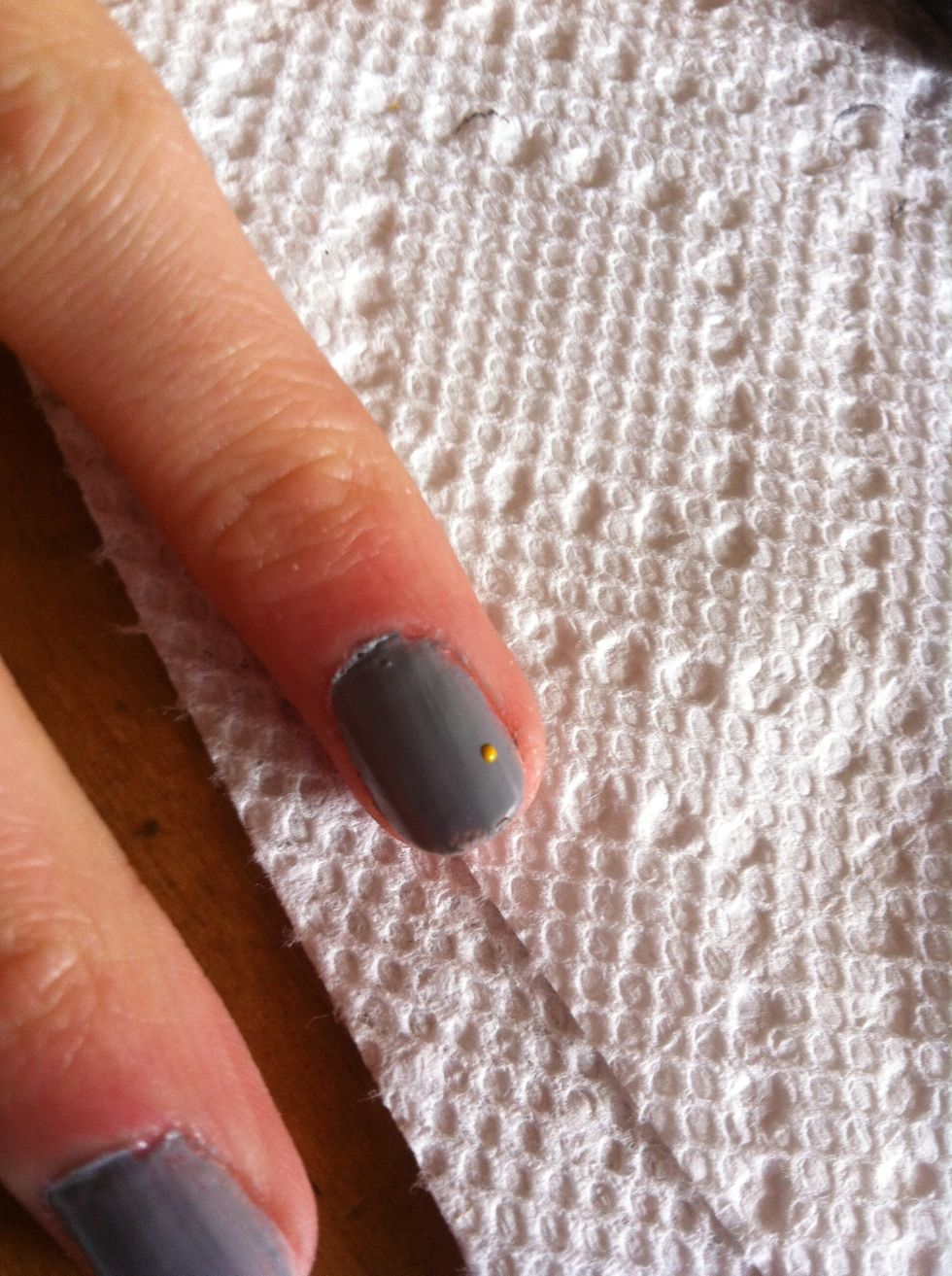 Use a dotter with yellow polish or a nail polish pen to make a small dot on the nail of your choice.