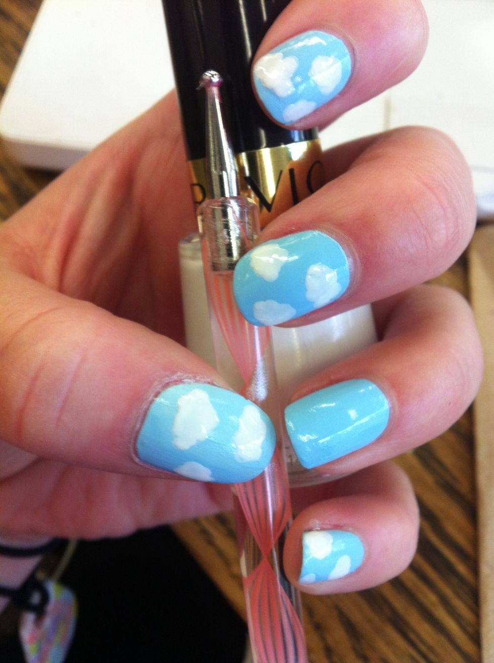 Use a dotting tool dipped in white polish to make fluffy cloud shapes on all your nails except one. These don't have to be perfect, just like real clouds!