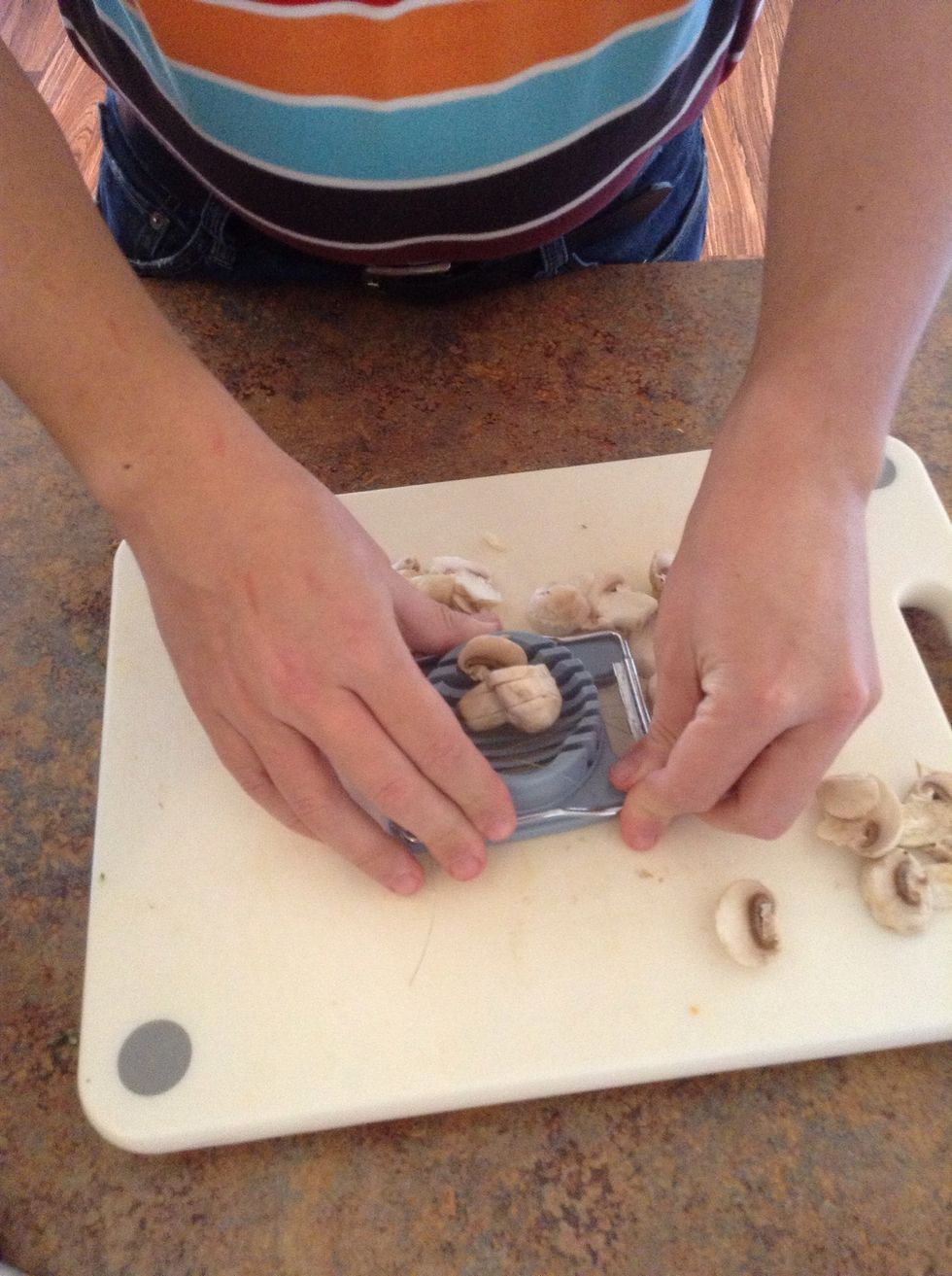 Use a eggs slicer to slice the mushrooms. Place mushroom on slicer when the handle is open then push the handle back down to slice.