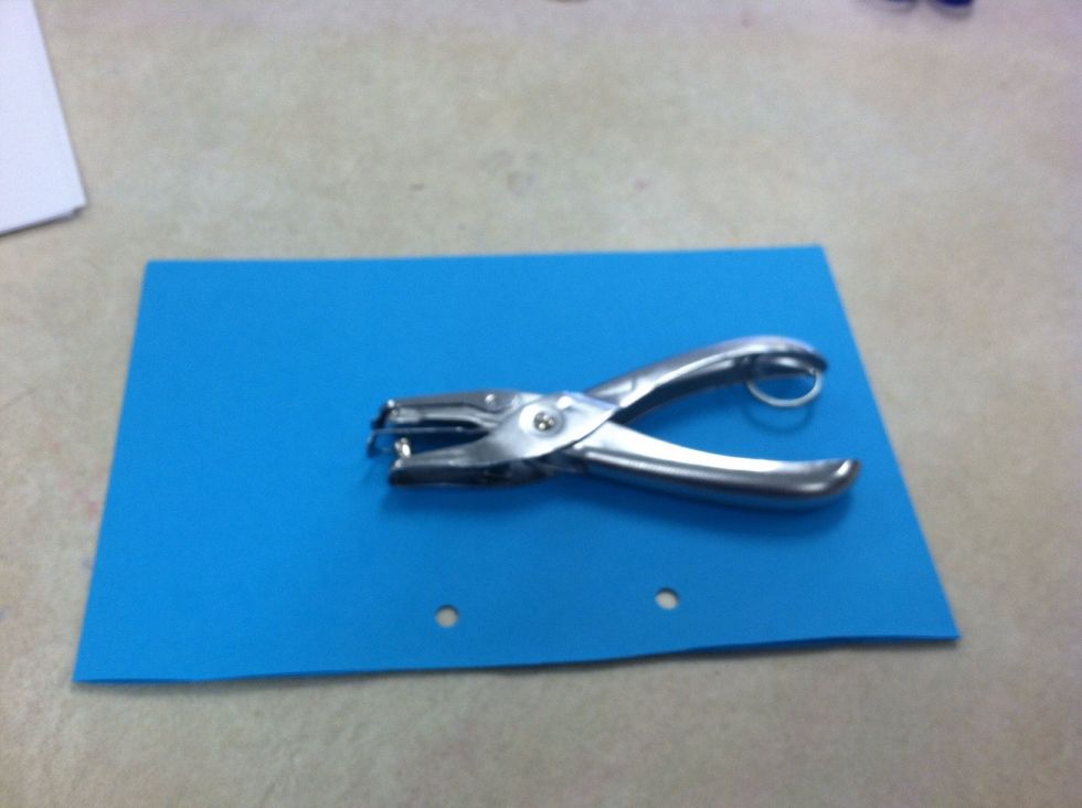 Use a hole punch to punch two holes about 1 1/2 inches across from each other. Cardstock 1 piece at a time. Paper is too thick to punch at the same time.