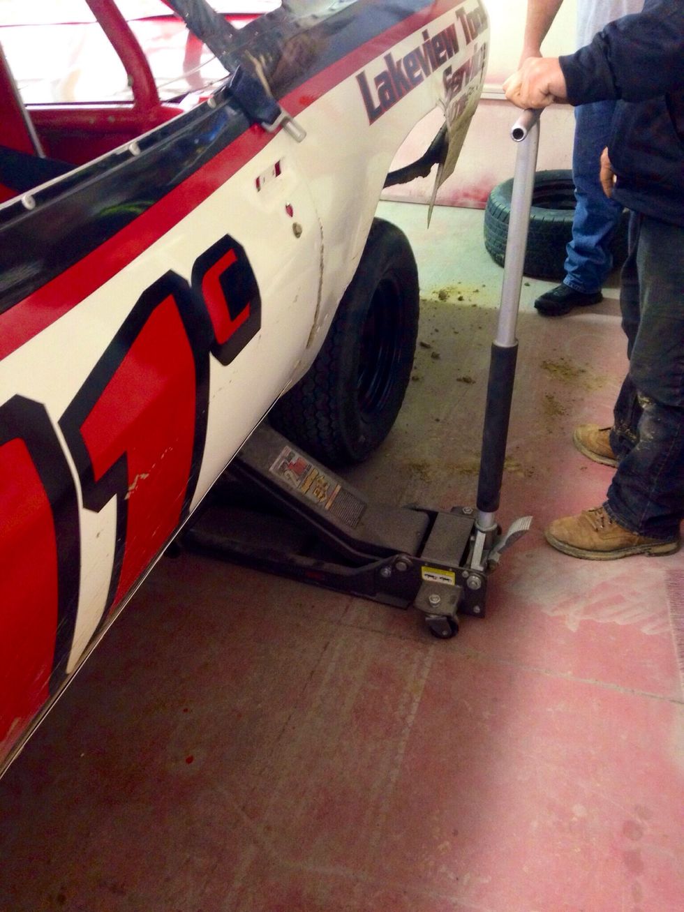 Use a jack to lift the car up so it is off the ground.