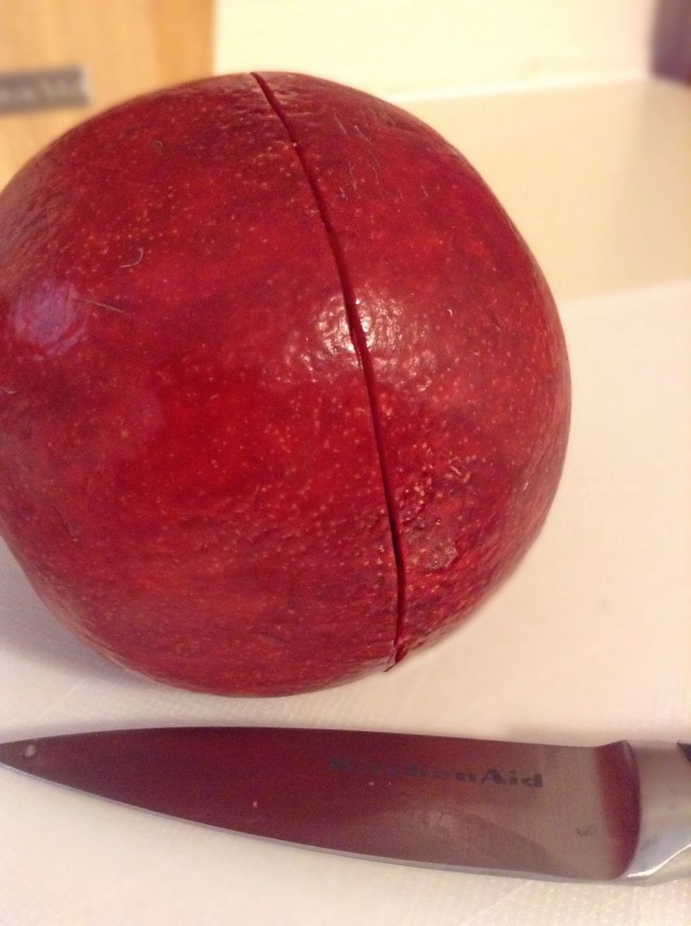 Use a knife to score the pomegranate. Your knife will go in just enough to cut through the outer layer of the pomegranate but not enough to harm the seeds. You'll do a complete circle :)!