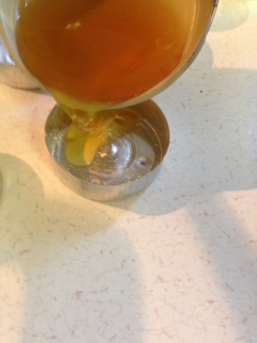 Use a ladle to carefully pour melted mixture into tea light molds.