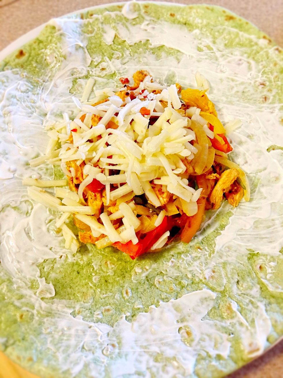 Use a large wrap. Apply mayo, sriracha, avocado/mango spread or any other flavor booster.  Put 3/4 c of chicken/veggie medley and top with cheese.