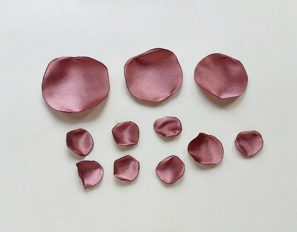 Use a lighter or candle to burn the sides of the round satin pieces. Carefully burn the sides of all the pieces. Satin fabric will curl around the sides nicely rather than satin ribbon.