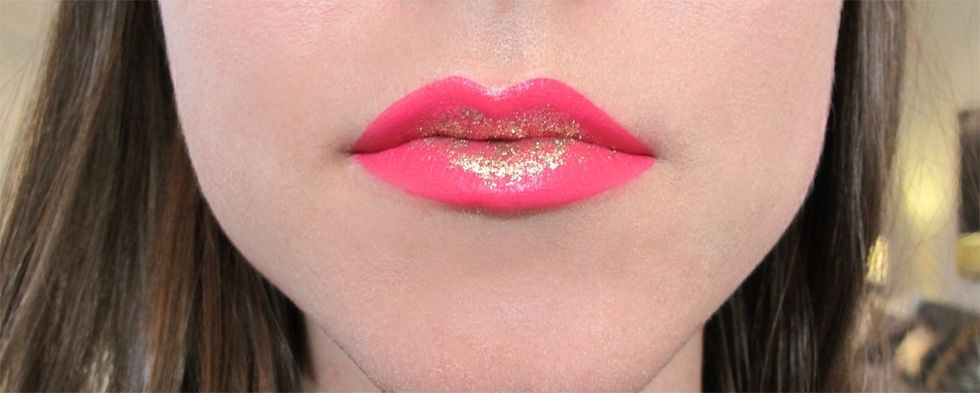 Use a lip brush to dab the gold glitter onto the center of the lips, both top and bottom. We used Sephora Glitter Eyeliner Gold 07.