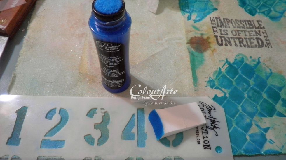 Use a makeup sponge to add Mediterranean Radiant Rain through a Tim Holtz number stencil by picking up the color from the dauber tip. This gave me total control and no bleed through.
