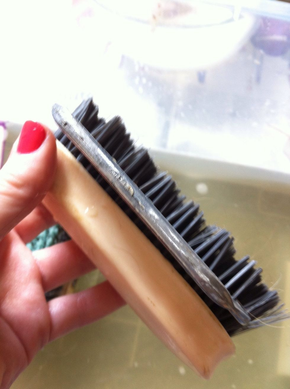 Use a mane and tail comb, and push it into the bristles and pull upwards to separate them and get any hairs out. Don't worry too much about hairs, they can come out later