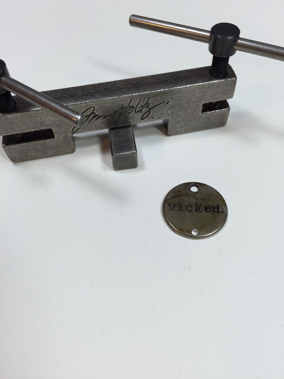 Use a metal hole punch tool like this one by Tim Holtz to make a second hole at the bottom of this word token.