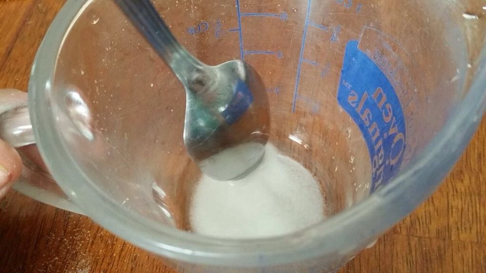 Use a metal spoon to mix the rice vinegar and the sugar in the measuring cup.