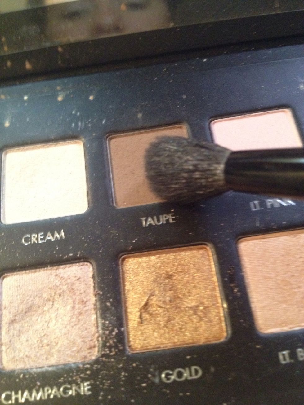 Use a neutral taupe shade and fluffy brush