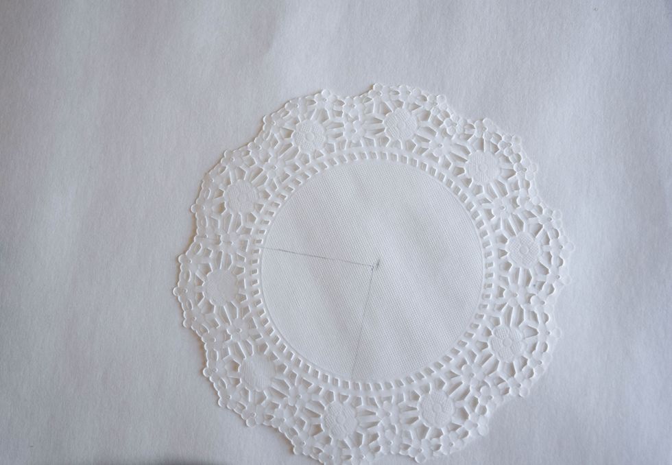 Use a pencil to mark the center of the doily. Starting from the center point draw one line to the bottom of the doily and one to the left so you mark roughly 1/4 of the doily.