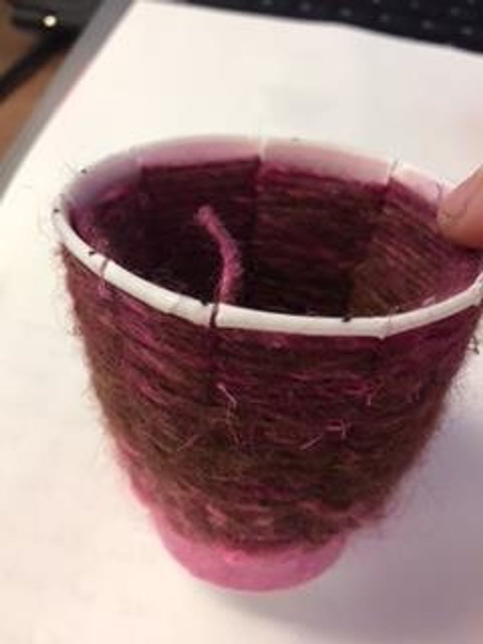 Use a pencil to tuck the tail behind the yarn on the inside of the cup.