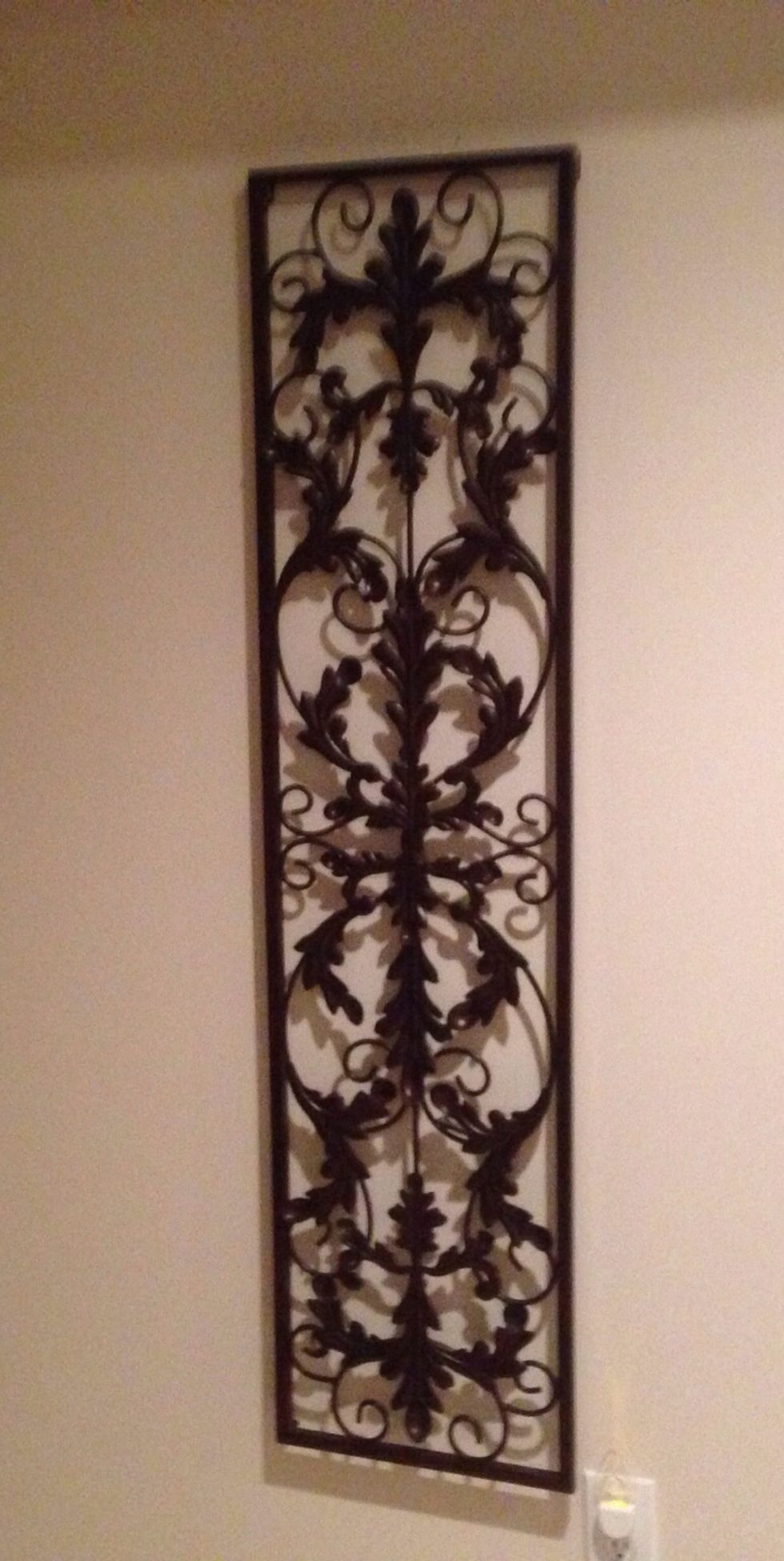 Use a piece of wall art that is sturdy metal and has plenty of nooks and crannies to hang your hooks.  The size and shape can be any as long as it will work for the number of cups you want to hang.