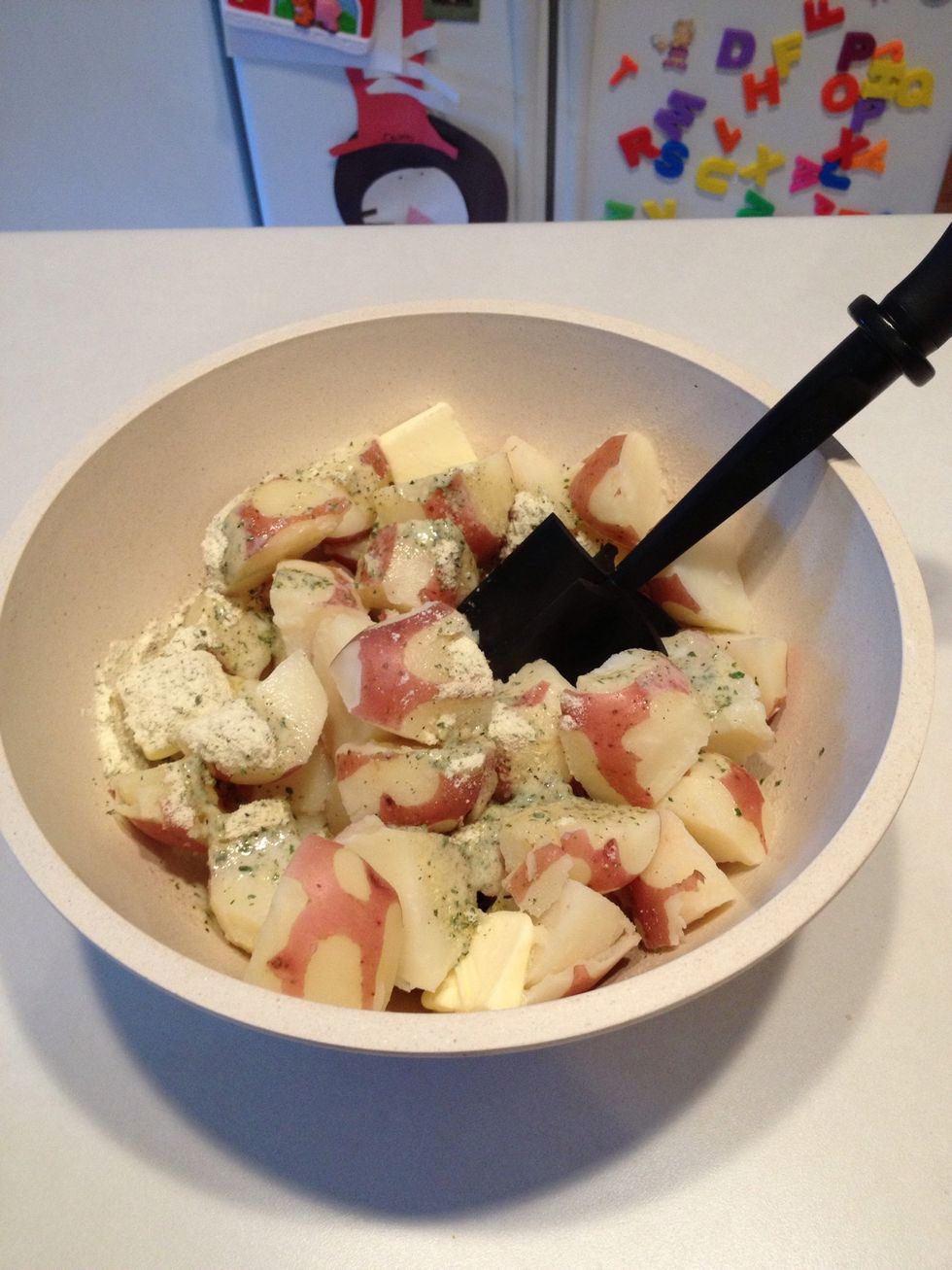 Use a potato masher to smash the potatoes and mix everything together.