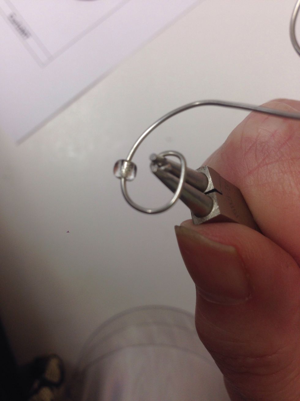Use a round nose plier to curve the beginning end of your wire into a tiny hook to hold the bead in place.