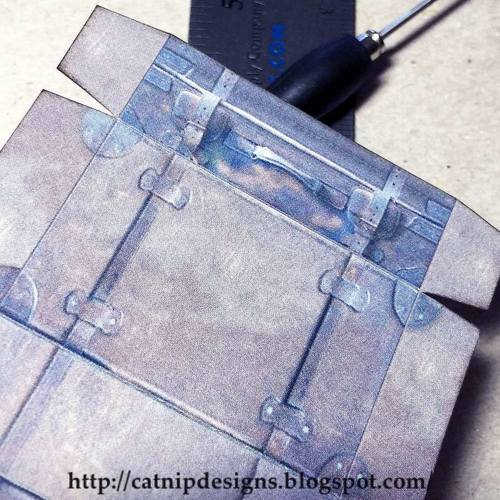 Use a ruler and a pointed stylus to score all of the fold lines on the luggage piece. This can also be done with any other scoring method.