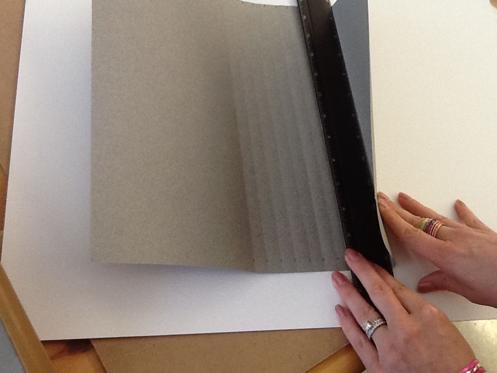 Use a ruler lined up to your marks to score the paper evenly, this will make it easier to fold later.