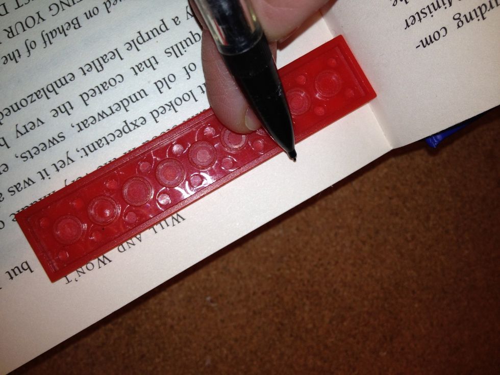Use a ruler (or in my case, a piece of Lego. It works just as well :) and pencil to draw marker lines on the book. Decide how far or close you want to cut near the edge of the pages.