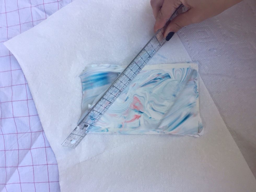 Use a ruler, or spatula, to scrape the shaving cream off of the card