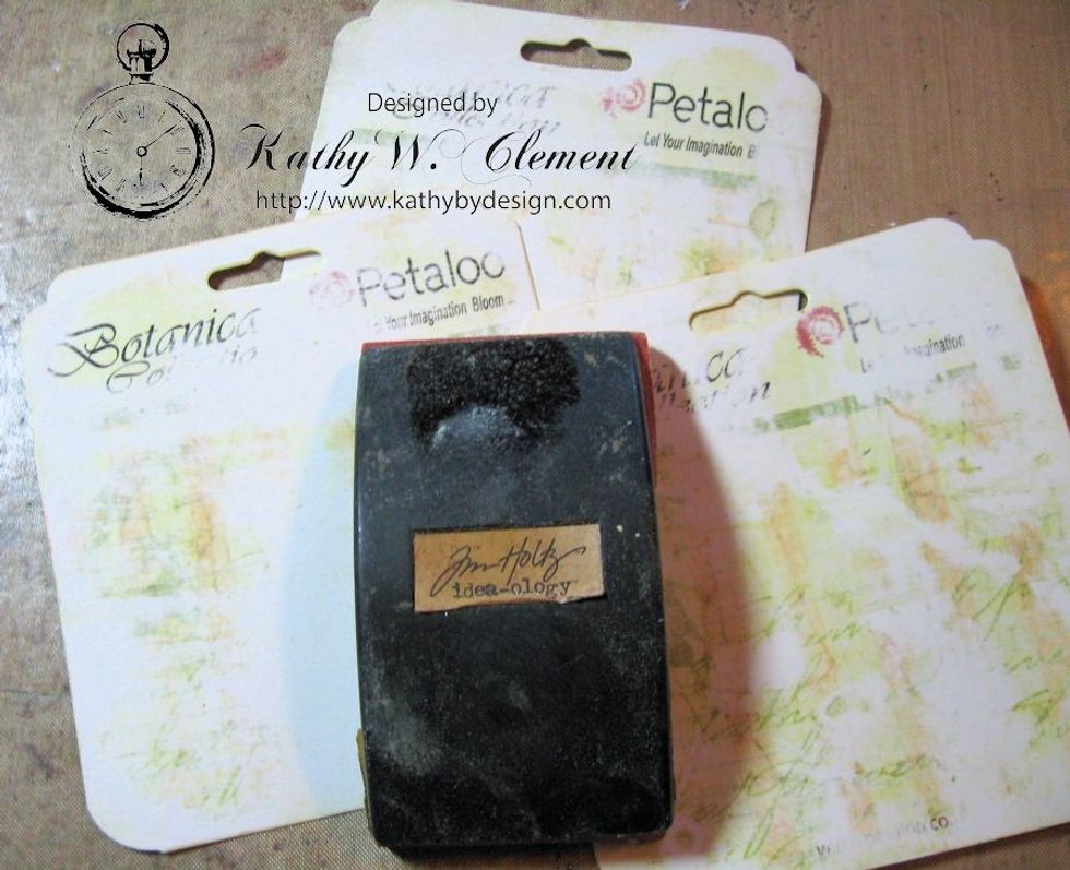 Use a sanding grip to rough up the surface of the tag, but don't remove all the pretty text and pattern. Focus on the printed part of the tag.