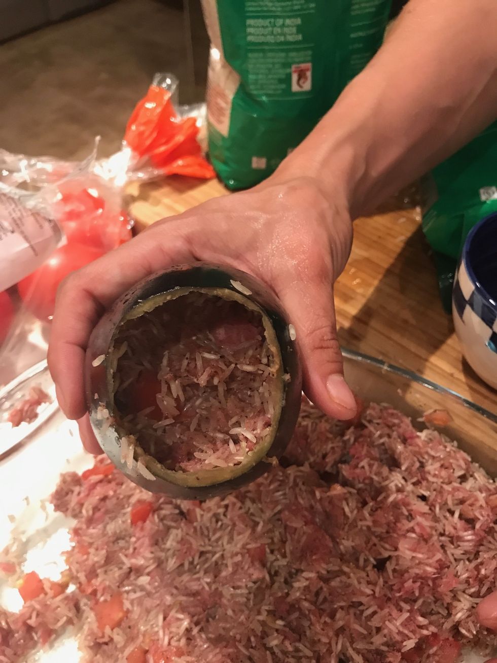 Use a scraper to cut the inside of 7 aubergines out and stuff it with the mix