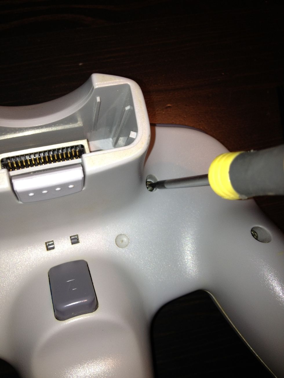 Use a screwdriver to unscrew all the screws on the back of the controller.