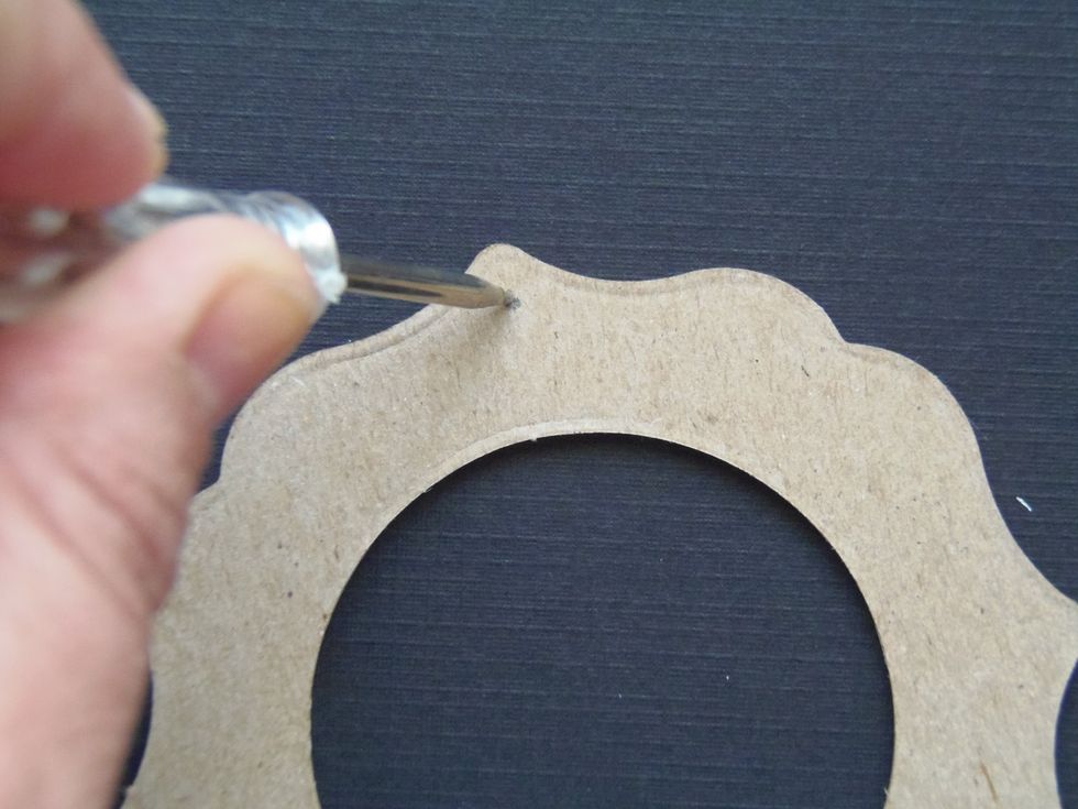 Use a sharp point to make a hole through the chipboard piece.