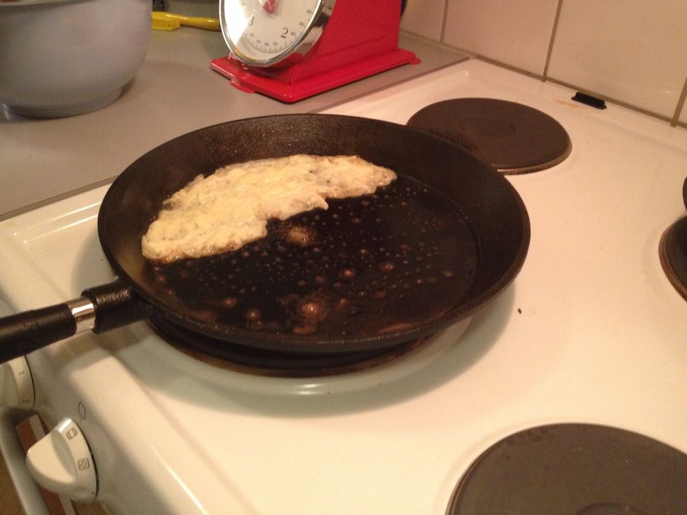 Use a small cup to measure how much batter to pour in the pan. Spread it out evenly in the skillet.