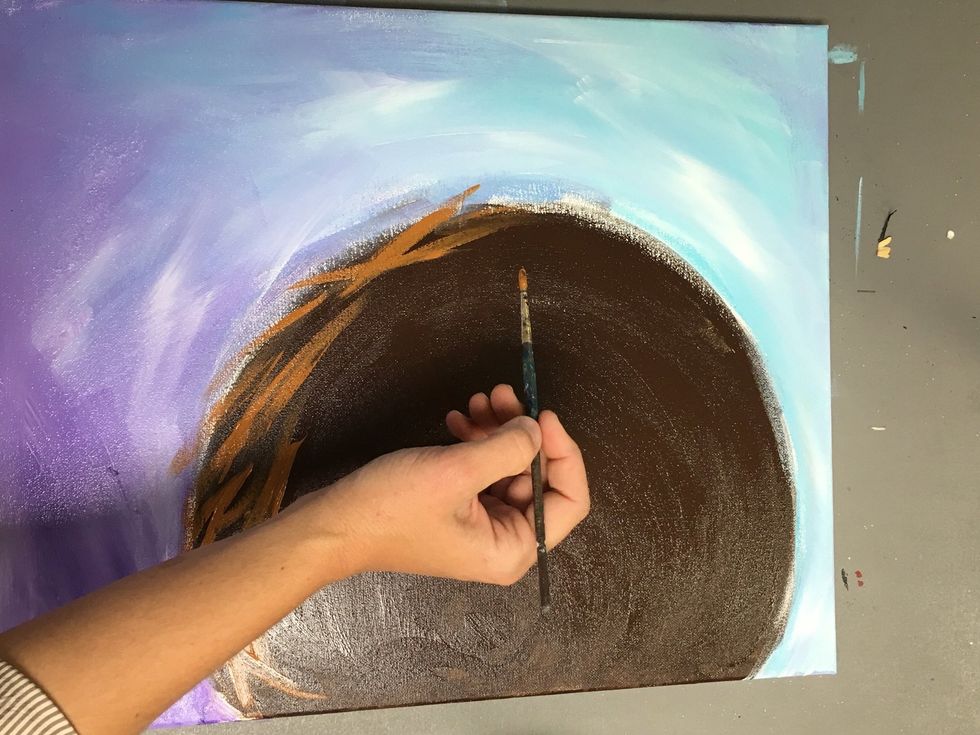 Use a small round tip brush and start with the darker of the three colors to add a twig like texture around the brown circle.  Brush strokes should go off the circle and cross each other.